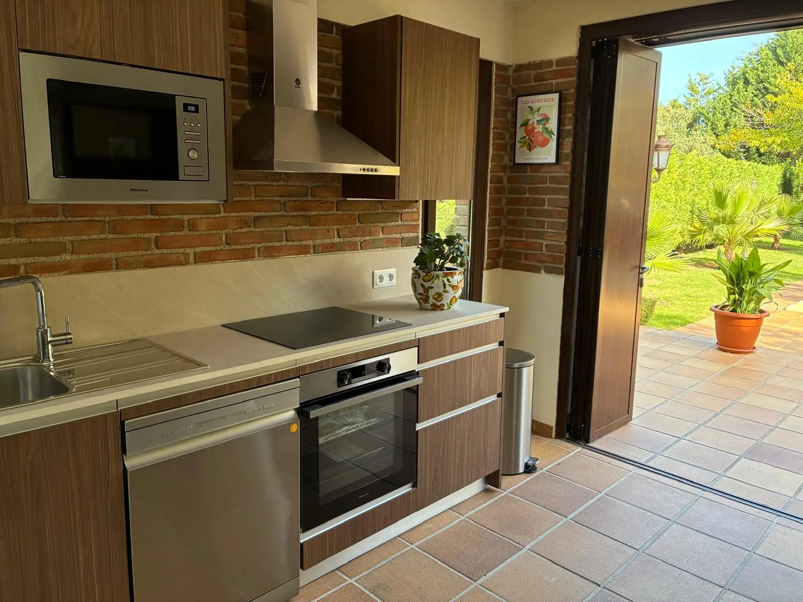 Cocina exterior de Quinta de Serena con horno, microondas y puerta al jardín