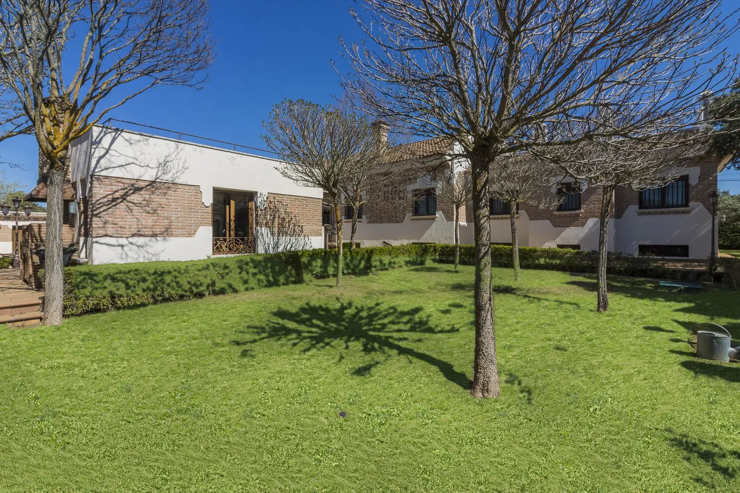 Fachada de la casa y jardín con árboles en Quinta de Serena