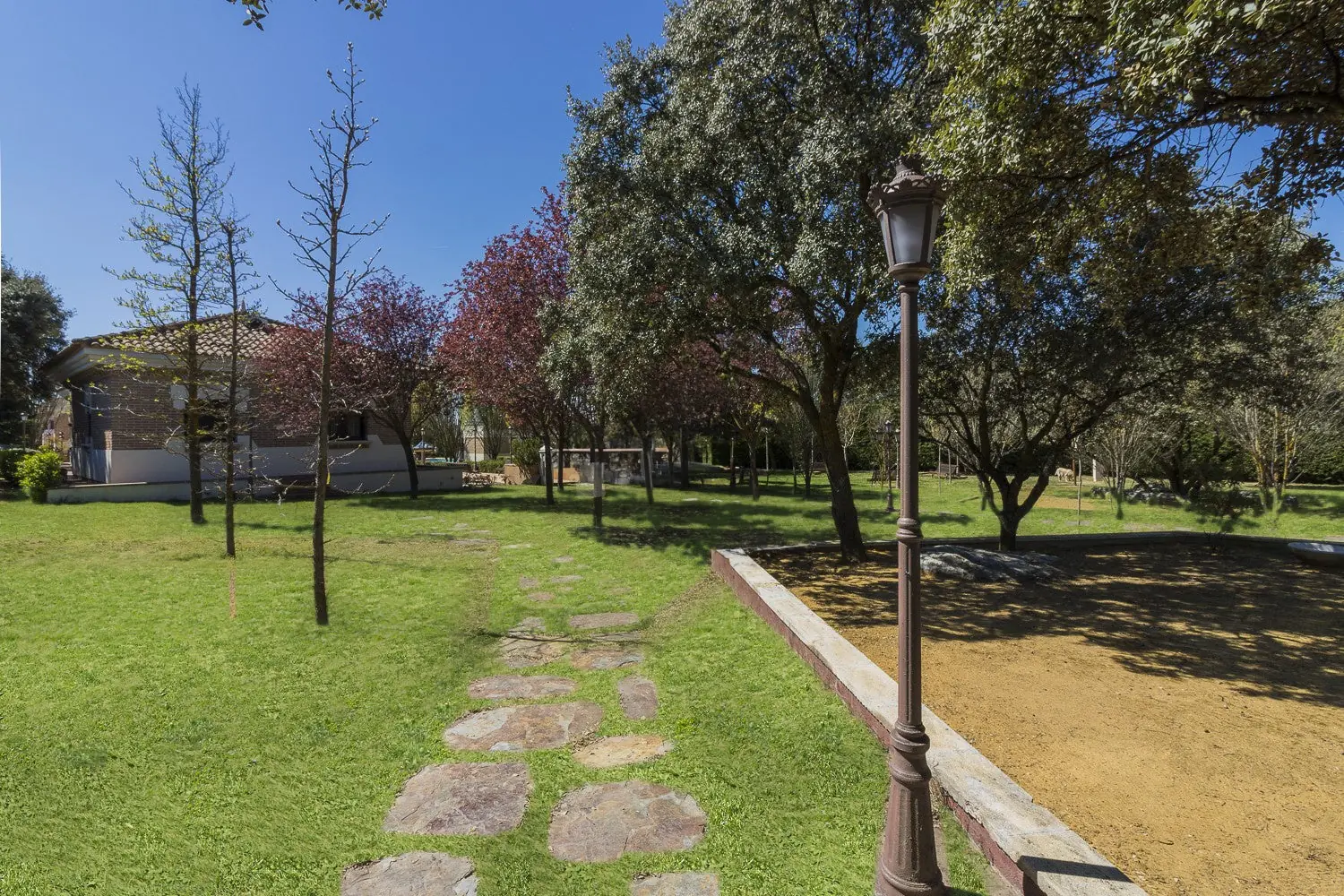 Jardín con sendero de piedra y farola en Quinta de Serena