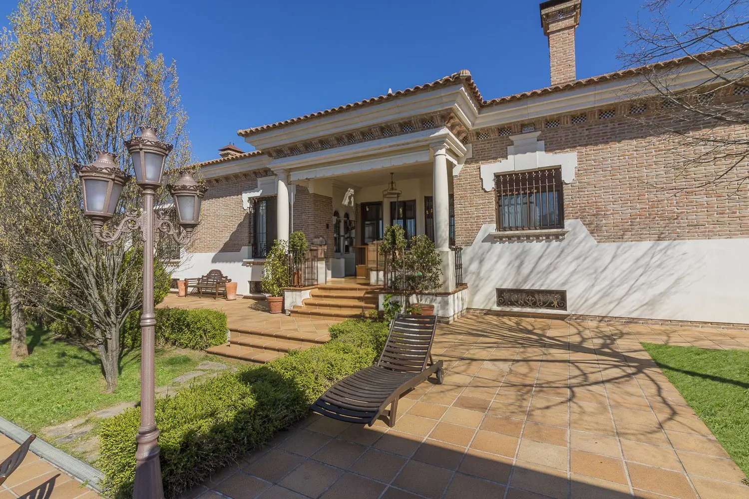 Porche de la casa con farola y tumbona en Quinta de Serena, finca para eventos en Nuevo Baztán
